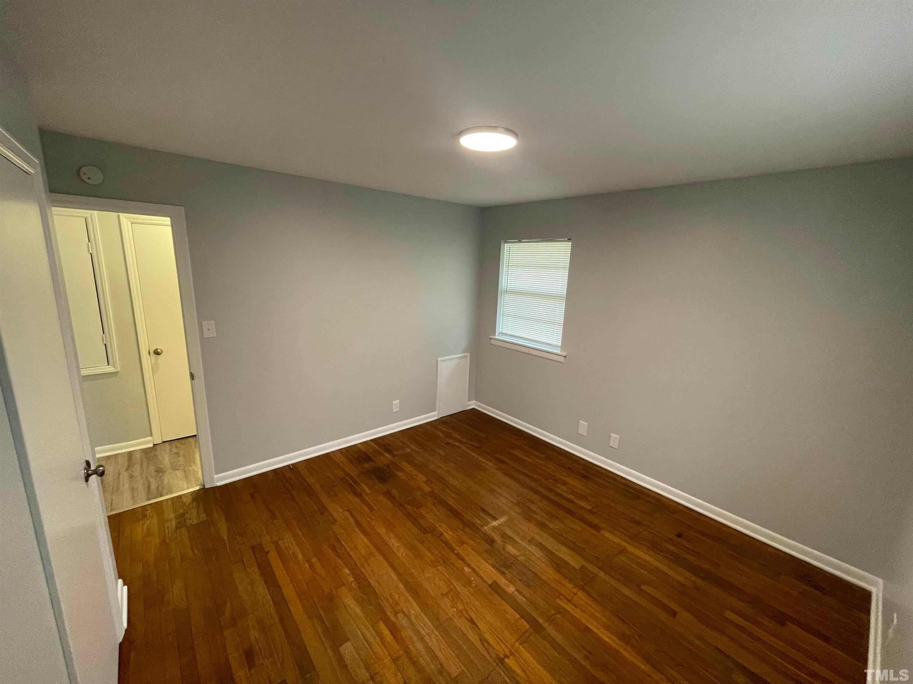 334 Clark Street, Unit A Durham, NC 27701 - Photo 15 of 16 an empty room with wooden floor and windows