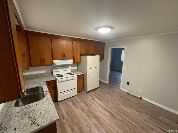 a kitchen with wooden floors and white appliances
