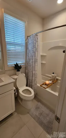 a bathroom with a granite countertop toilet sink and mirror
