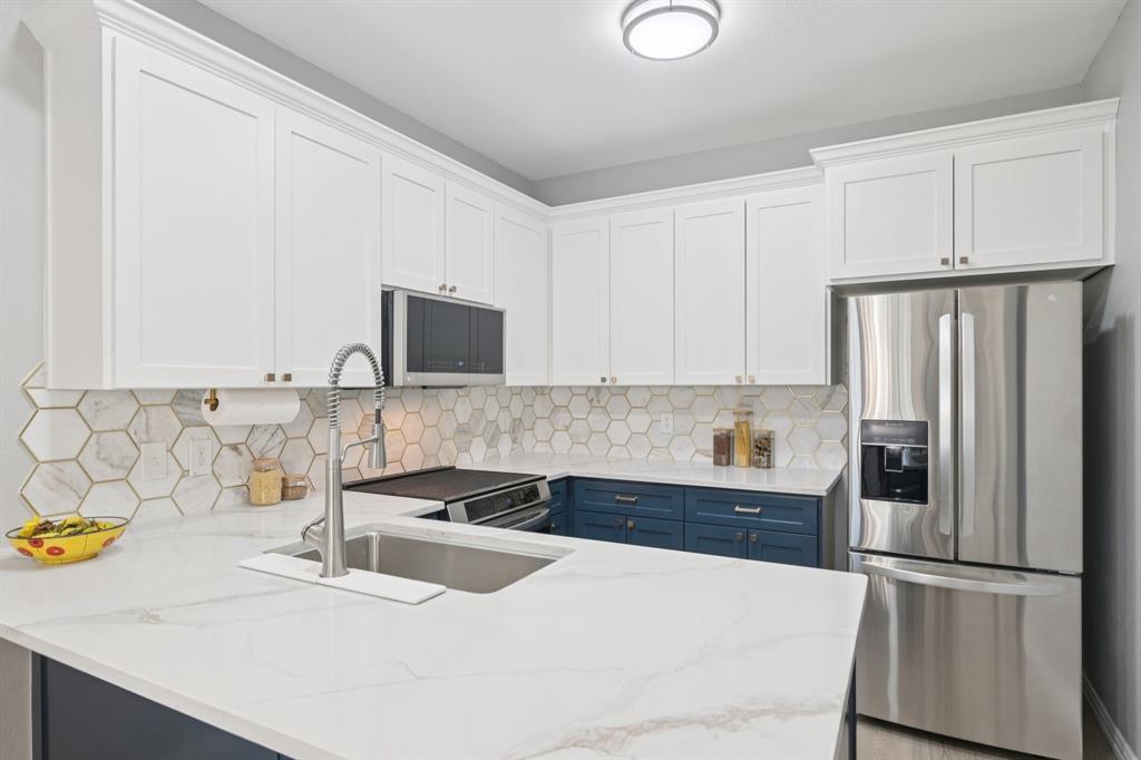209 Cimarron Trail, Unit 6 Irving, TX 75063 - Photo 1 of 39 a kitchen with stainless steel appliances a sink and a refrigerator