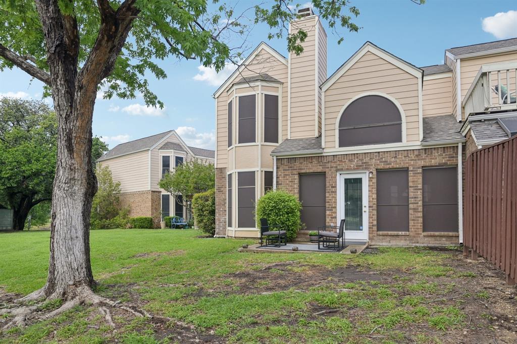 209 Cimarron Trail, Unit 6 Irving, TX 75063 - Photo 20 of 39 a view of a white house with a small yard and large tree