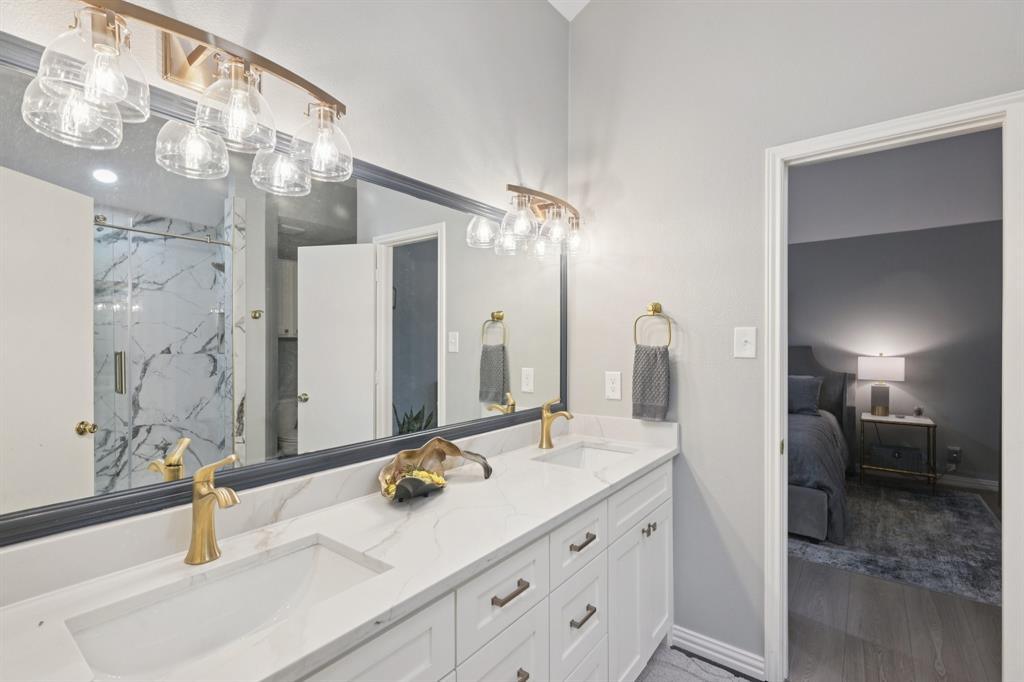209 Cimarron Trail, Unit 6 Irving, TX 75063 - Photo 35 of 39 a bathroom with a double vanity sink and a mirror