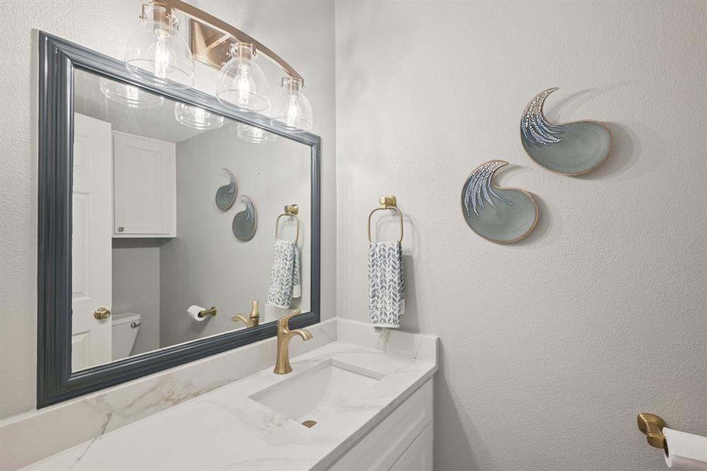 209 Cimarron Trail, Unit 6 Irving, TX 75063 - Photo 7 of 39 a bathroom with a sink and a mirror