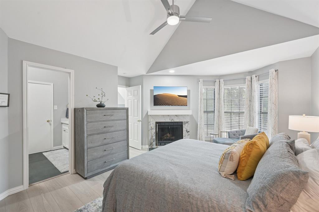 209 Cimarron Trail, Unit 6 Irving, TX 75063 - Photo 8 of 39 a bedroom with a bed and a fireplace