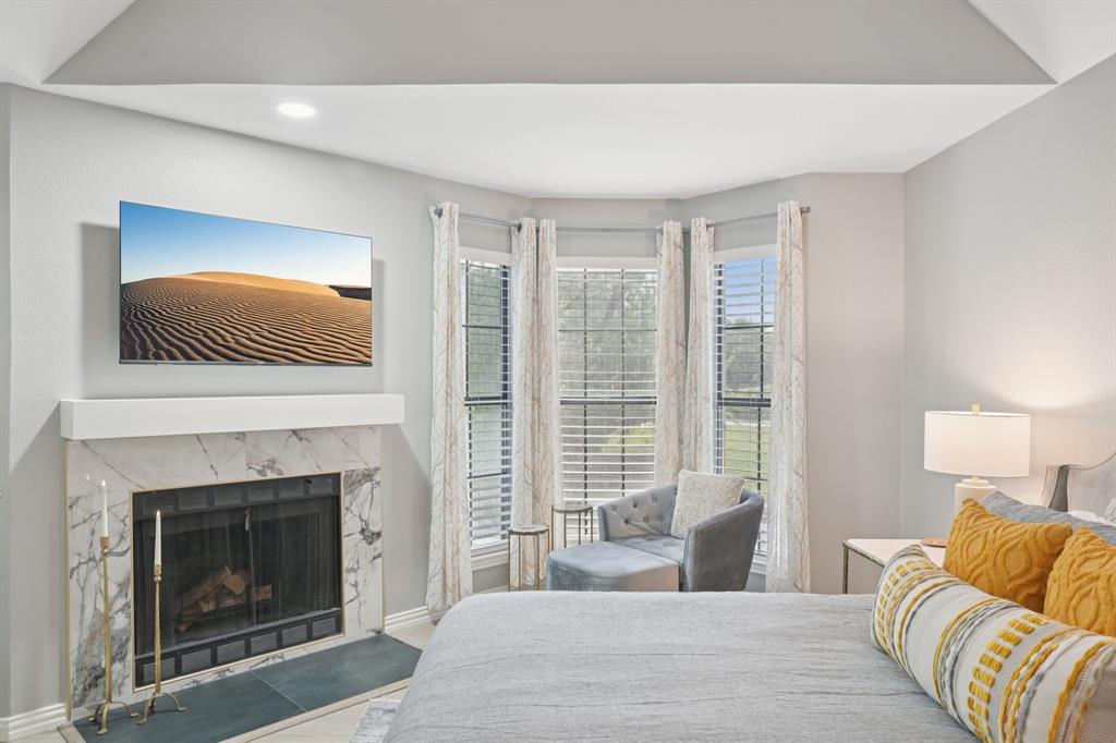 209 Cimarron Trail, Unit 6 Irving, TX 75063 - Photo 9 of 39 a bedroom with a bed and a fireplace