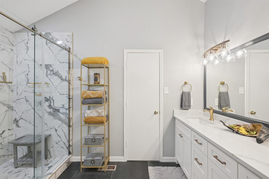209 Cimarron Trail, Unit 6 Irving, TX 75063 - Photo 10 of 39 a bathroom with a double vanity sink a mirror a vanity and a shower
