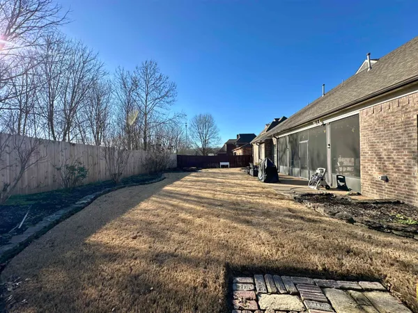 a view of a house with backyard and trees