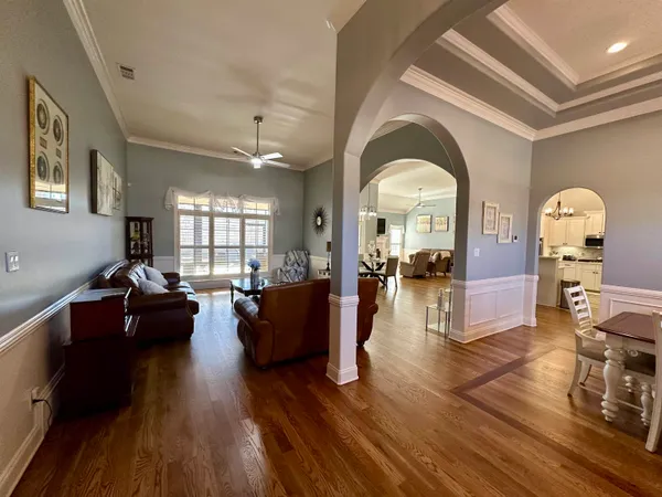 a living room with couches dresser with wooden floor