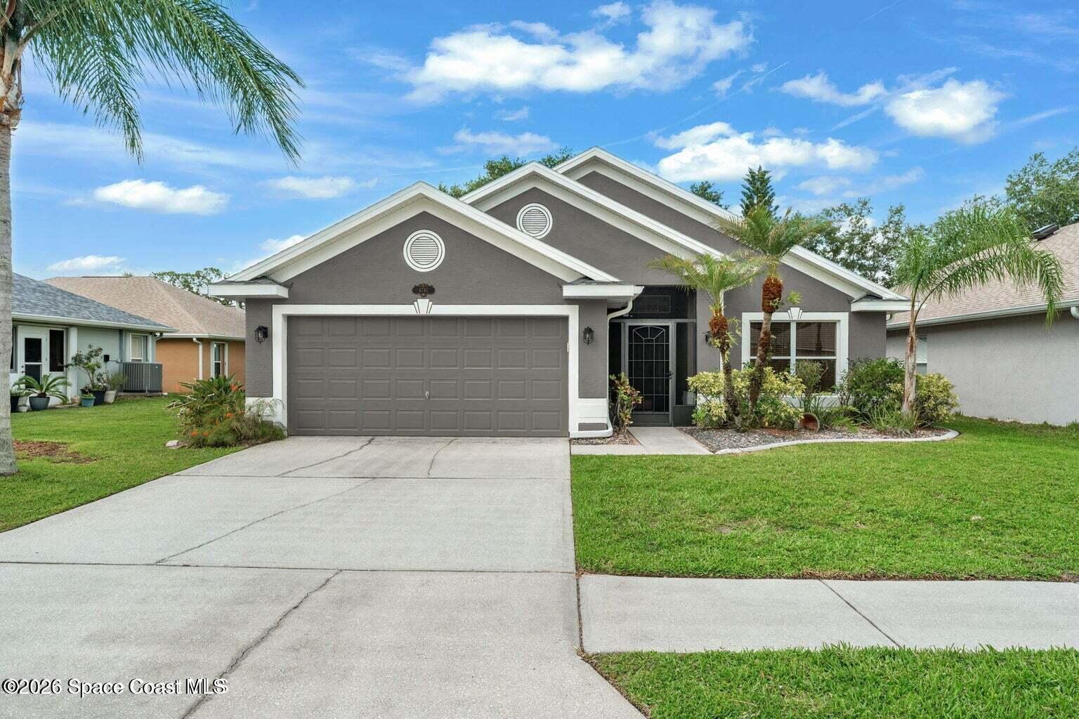 4741 Decatur Circle Melbourne, FL 32934 - Photo 39 of 44 a front view of a house with a garden and trees
