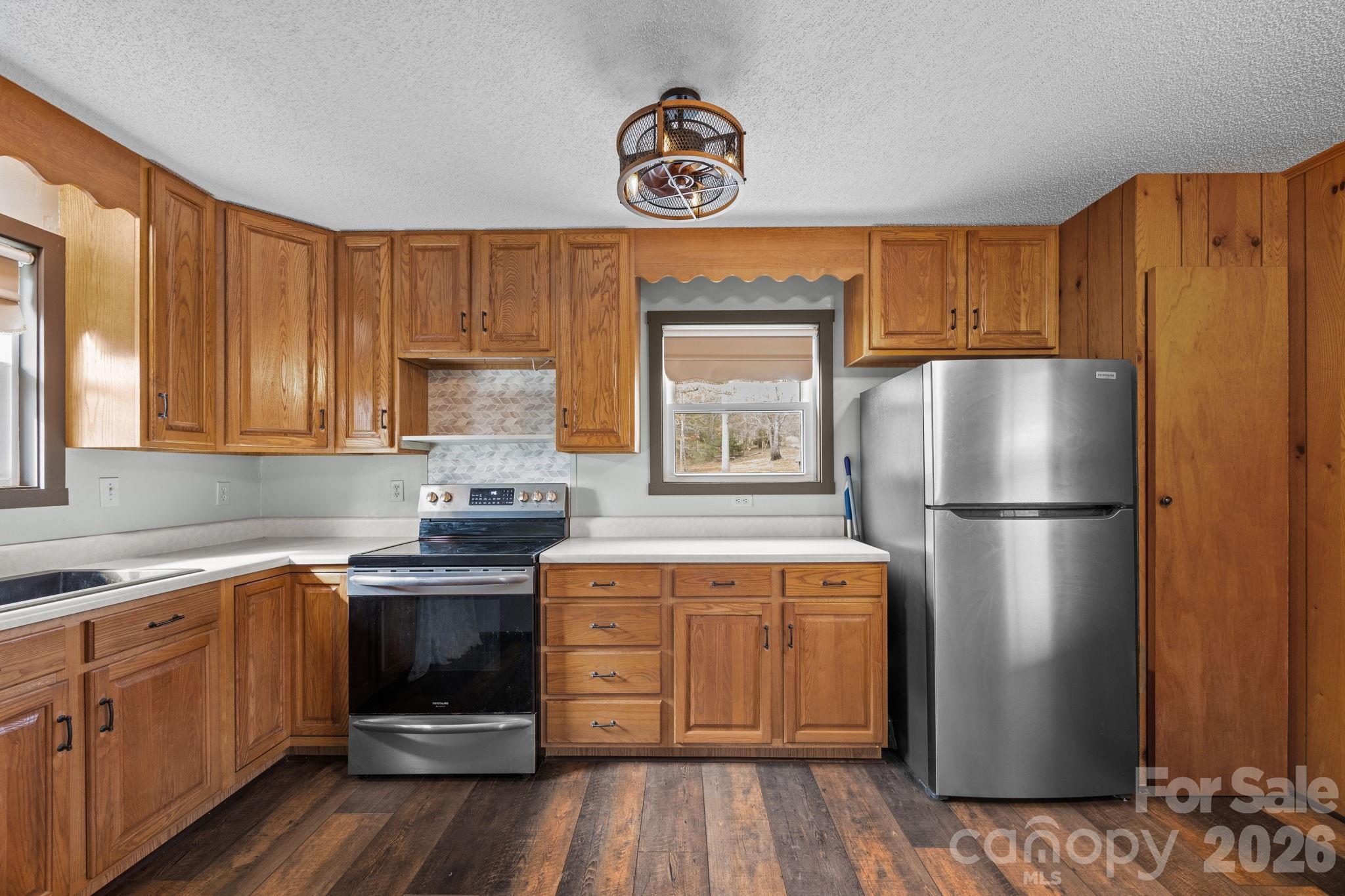 1169 Rickman Creek Road Franklin, NC 28734 - Photo 17 of 43 a kitchen with stainless steel appliances a refrigerator sink and cabinets