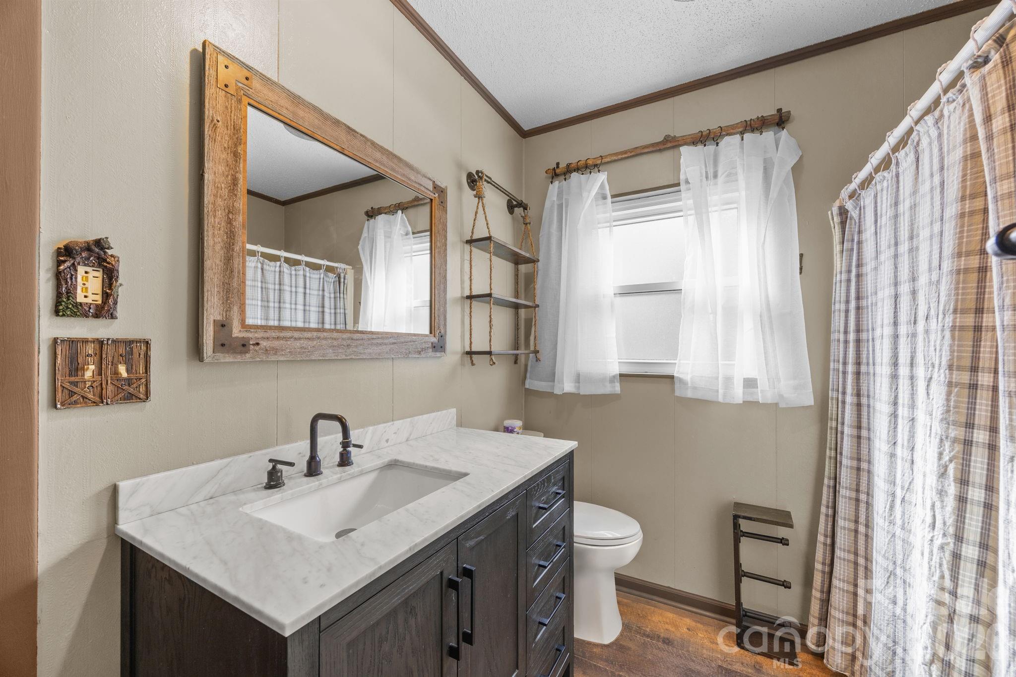 1169 Rickman Creek Road Franklin, NC 28734 - Photo 27 of 43 a bathroom with a toilet sink and mirror