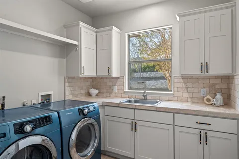 a view of a sink a washer and dryer in a kitchen