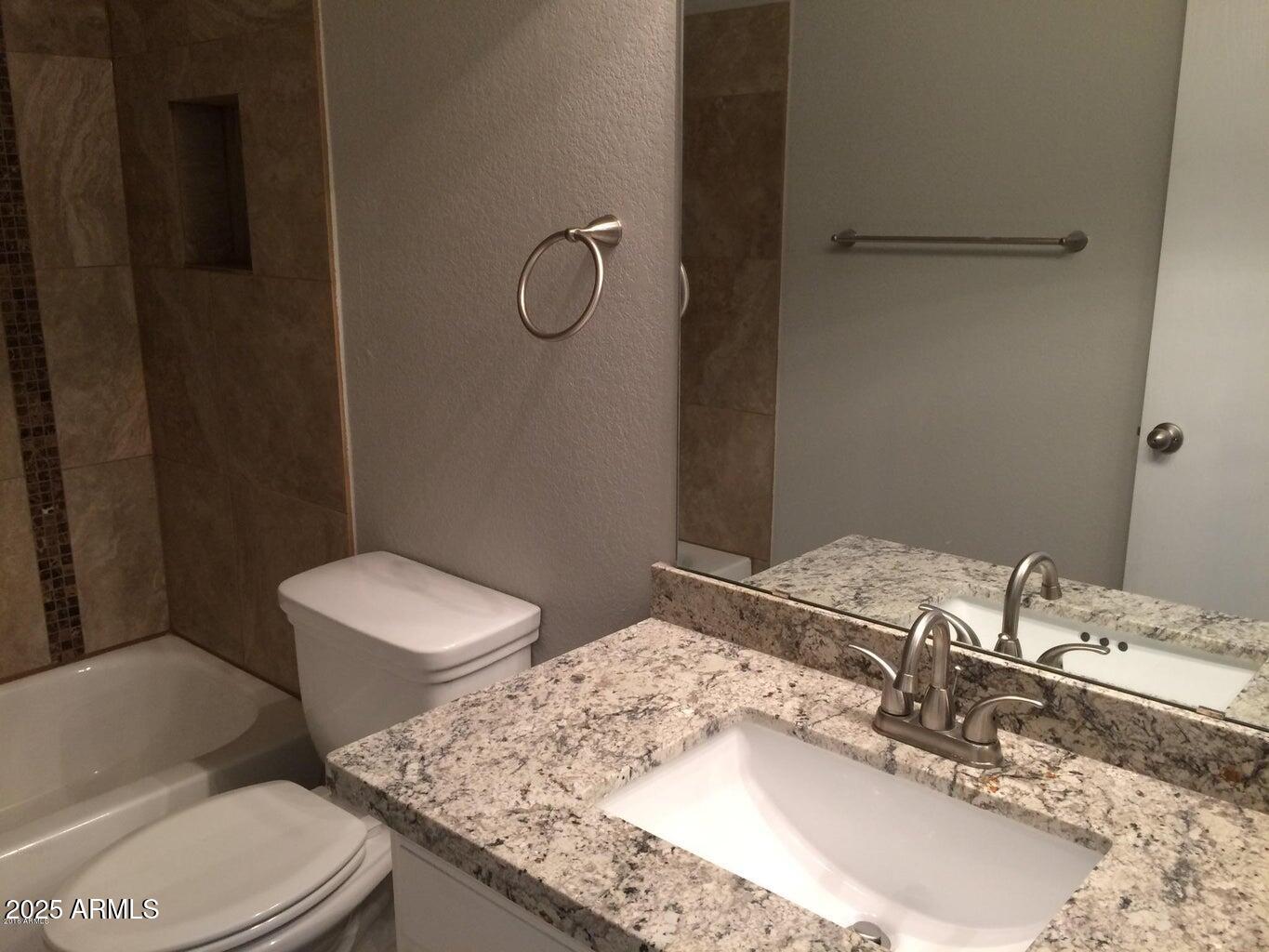 2240 East Aire Libre Avenue Phoenix, AZ 85022 - Photo 14 of 18 a bathroom with a granite countertop sink and a mirror