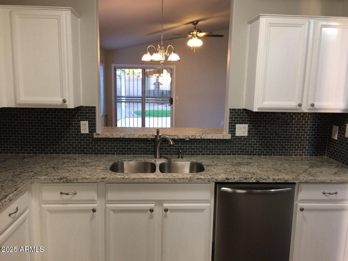 2240 East Aire Libre Avenue Phoenix, AZ 85022 - Photo 2 of 18 a kitchen with granite countertop a sink and white cabinets