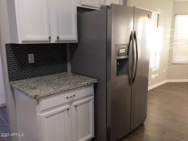 a bathroom with a granite countertop sink and refrigerator