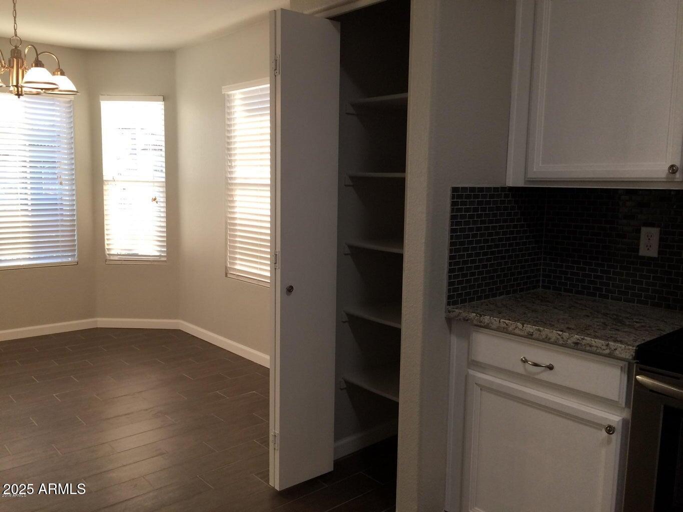 2240 East Aire Libre Avenue Phoenix, AZ 85022 - Photo 8 of 18 an empty room with wooden floor and windows