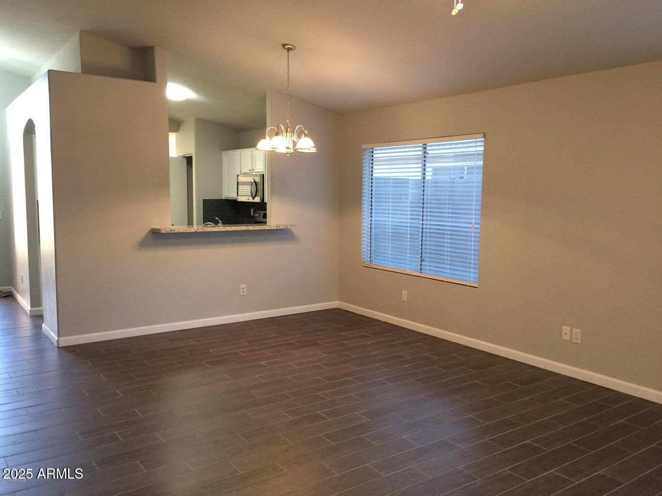 2240 East Aire Libre Avenue Phoenix, AZ 85022 - Photo 10 of 18 wooden floor in an empty room with a window