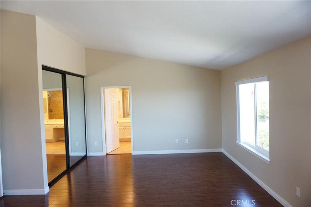 19584 Shadow Glen Circle Porter Ranch, CA 91326 - Photo 22 of 72 a view of an empty room with wooden floor and a window