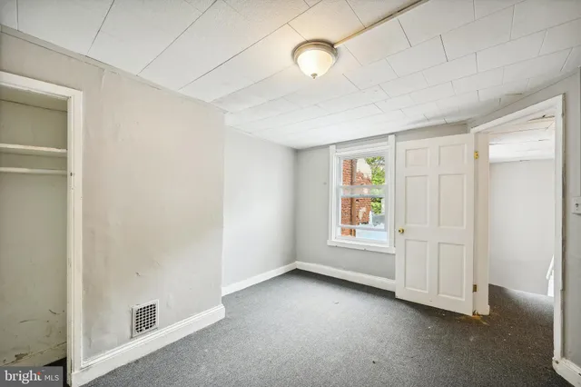 an empty room with windows and closet