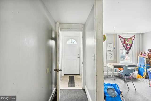 a view of a hallway with a white walls and stairs