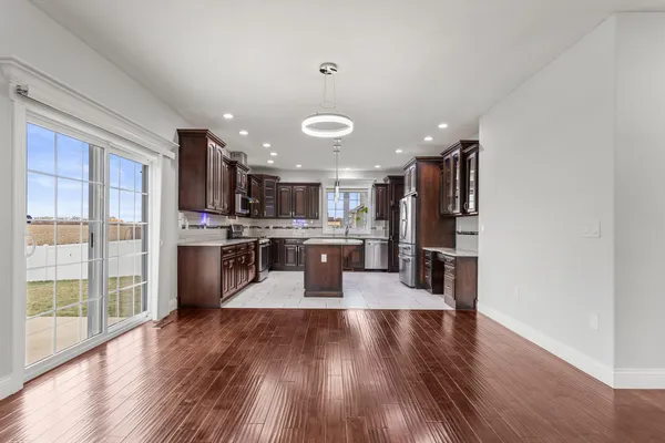 a kitchen with stainless steel appliances kitchen island wooden cabinets and wooden floor