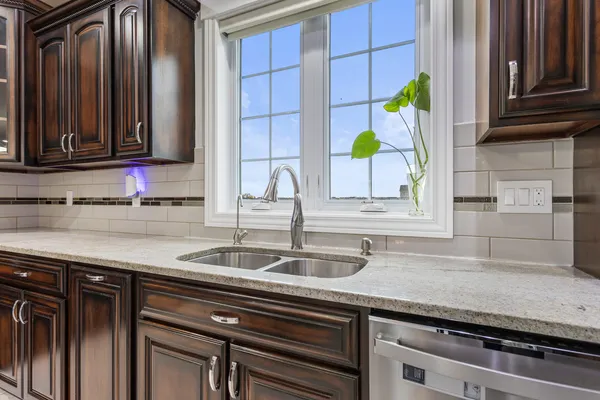 a kitchen with granite countertop a sink stainless steel appliances and cabinets
