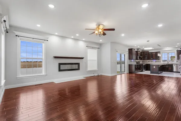 wooden floor in an empty room with a kitchen