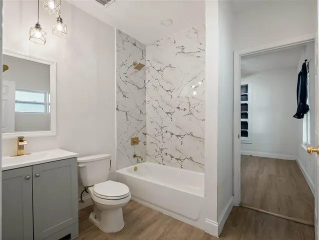a bathroom with a bathtub shower sink vanity and toilet