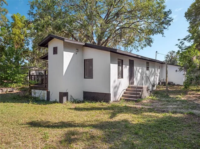 a view of a house with backyard and sitting area