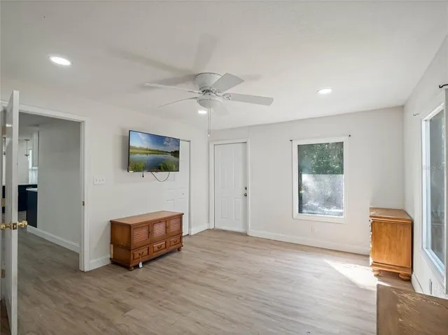 a view of an empty room with a window and wooden floor