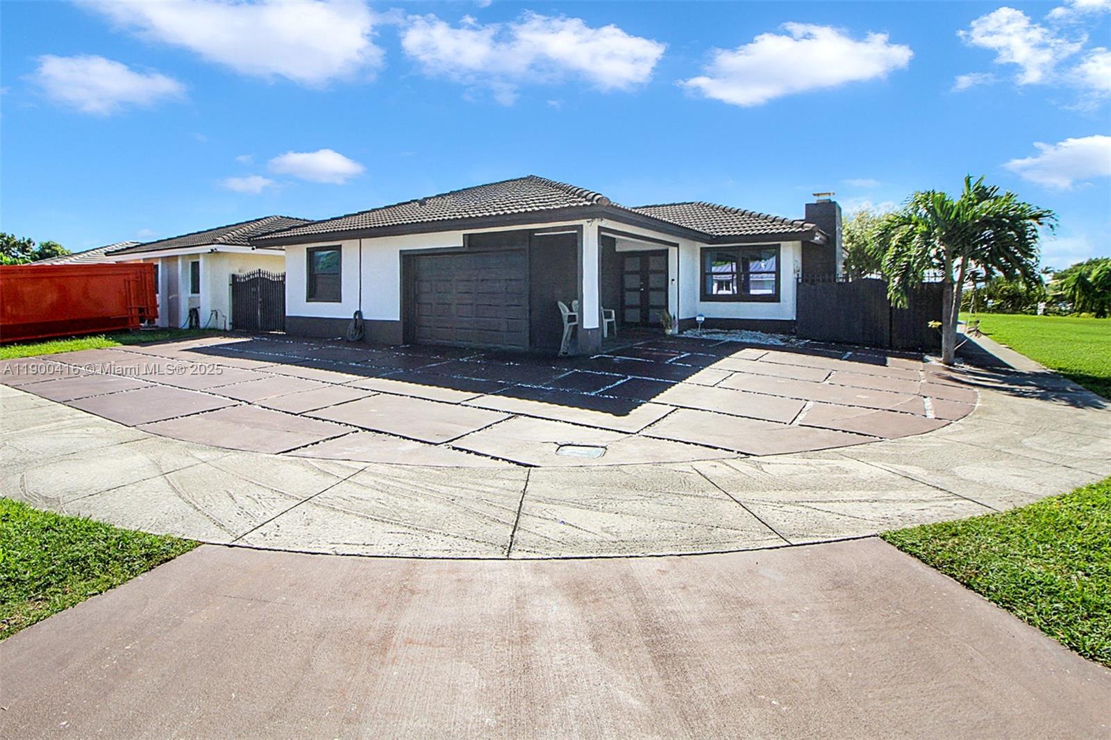 14880 Southwest 56th Terrace Miami, FL 33193 - Photo 2 of 35 a front view of a house with a yard and garage