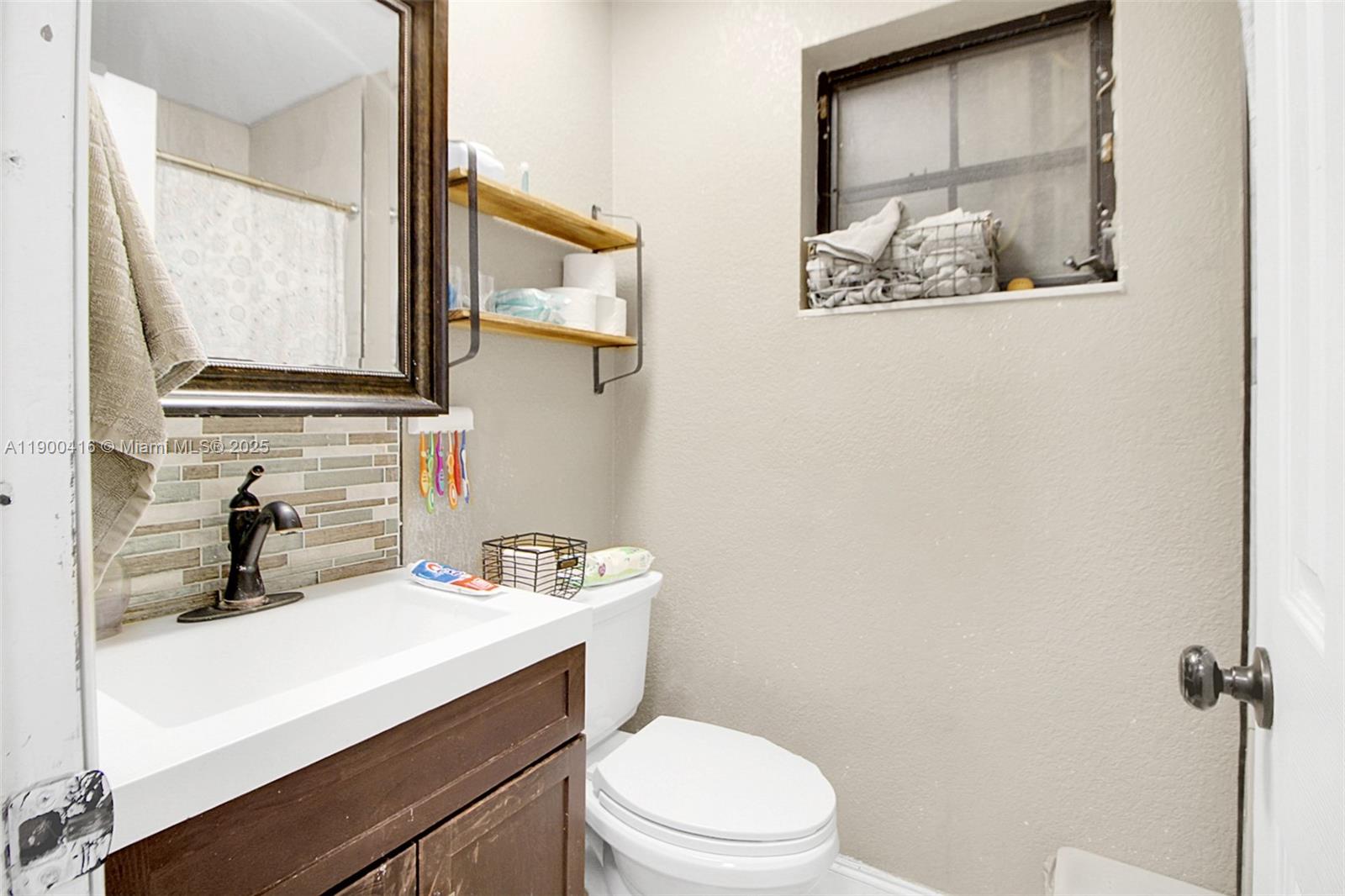 14880 Southwest 56th Terrace Miami, FL 33193 - Photo 24 of 35 a bathroom with a toilet sink and mirror