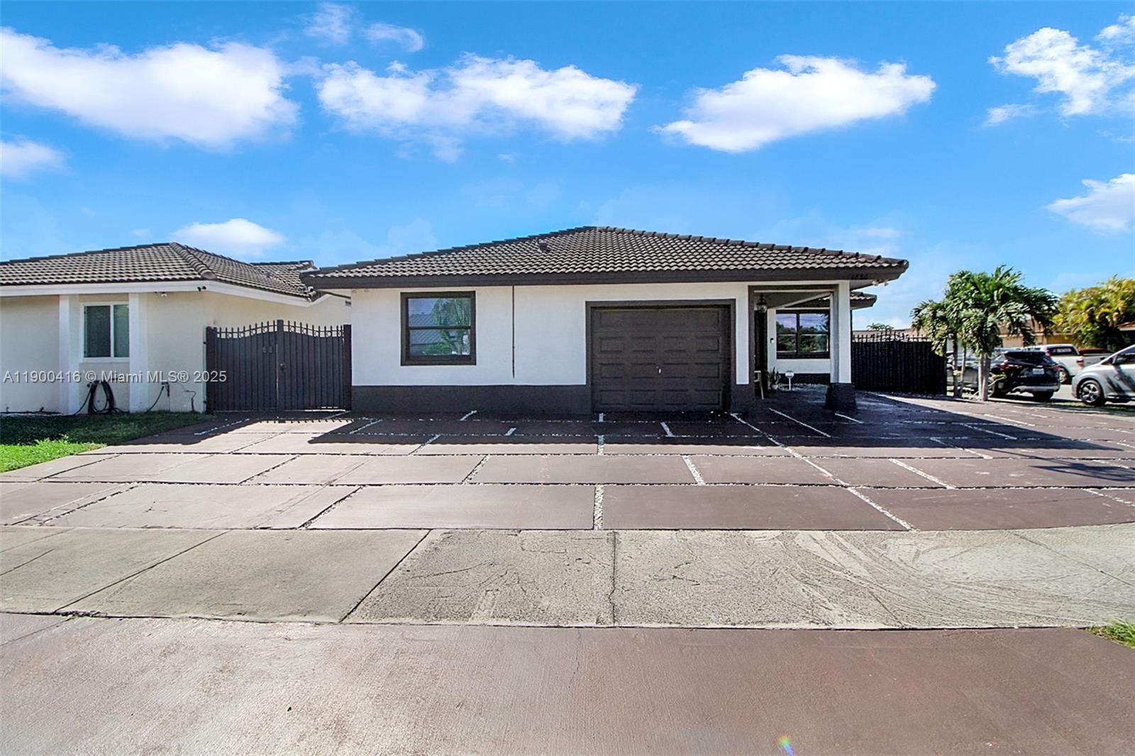 14880 Southwest 56th Terrace Miami, FL 33193 - Photo 3 of 35 a front view of a house with a yard and a garage