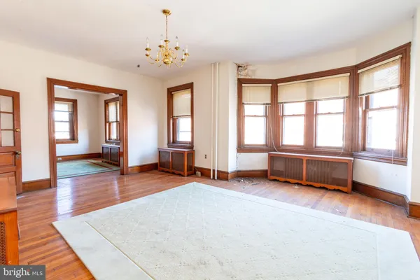 a spacious bedroom with a bed and wooden floor