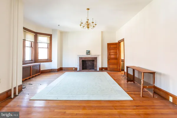 a spacious bedroom with a bed and wooden floor