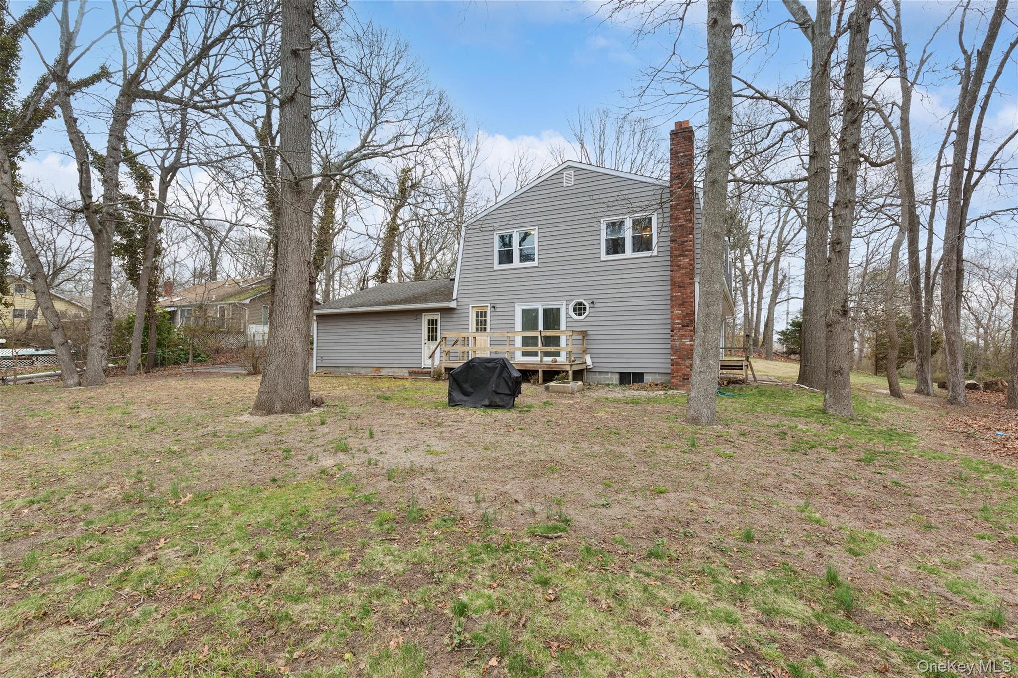 49 Overhill Road Wading River, NY 11792 - Photo 24 of 27 a view of a white house that has a tree in front of it
