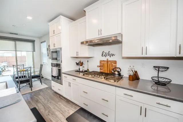 a kitchen with refrigerator a sink and wooden cabinets