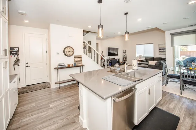 a open kitchen with stainless steel appliances kitchen island granite countertop a table chairs and a refrigerator