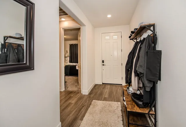 a kitchen with stainless steel appliances a dining table chairs refrigerator and sink