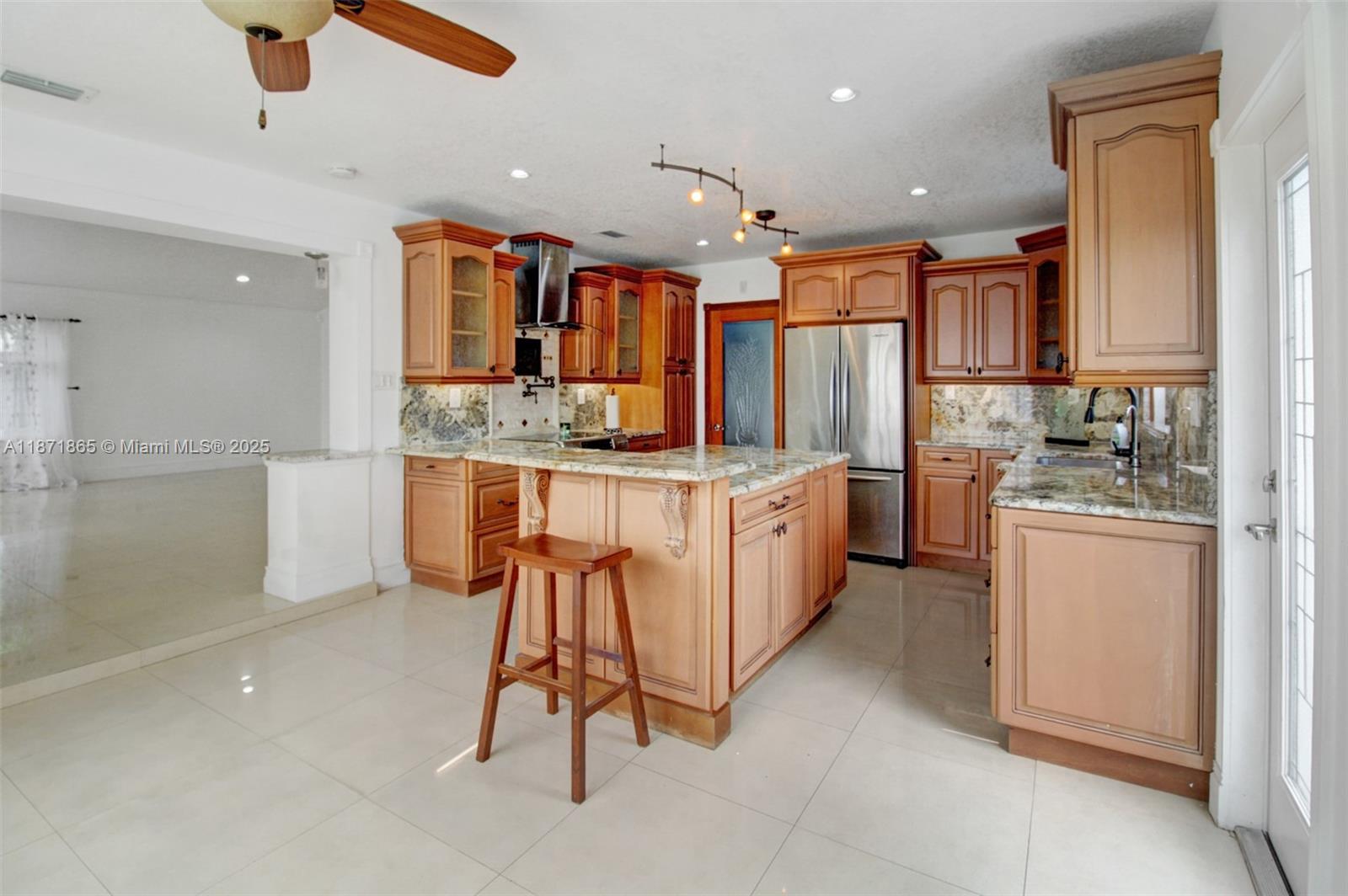 9930 Southwest 48th Street Miami, FL 33165 - Photo 12 of 29 a kitchen with stainless steel appliances kitchen island granite countertop a sink and cabinets