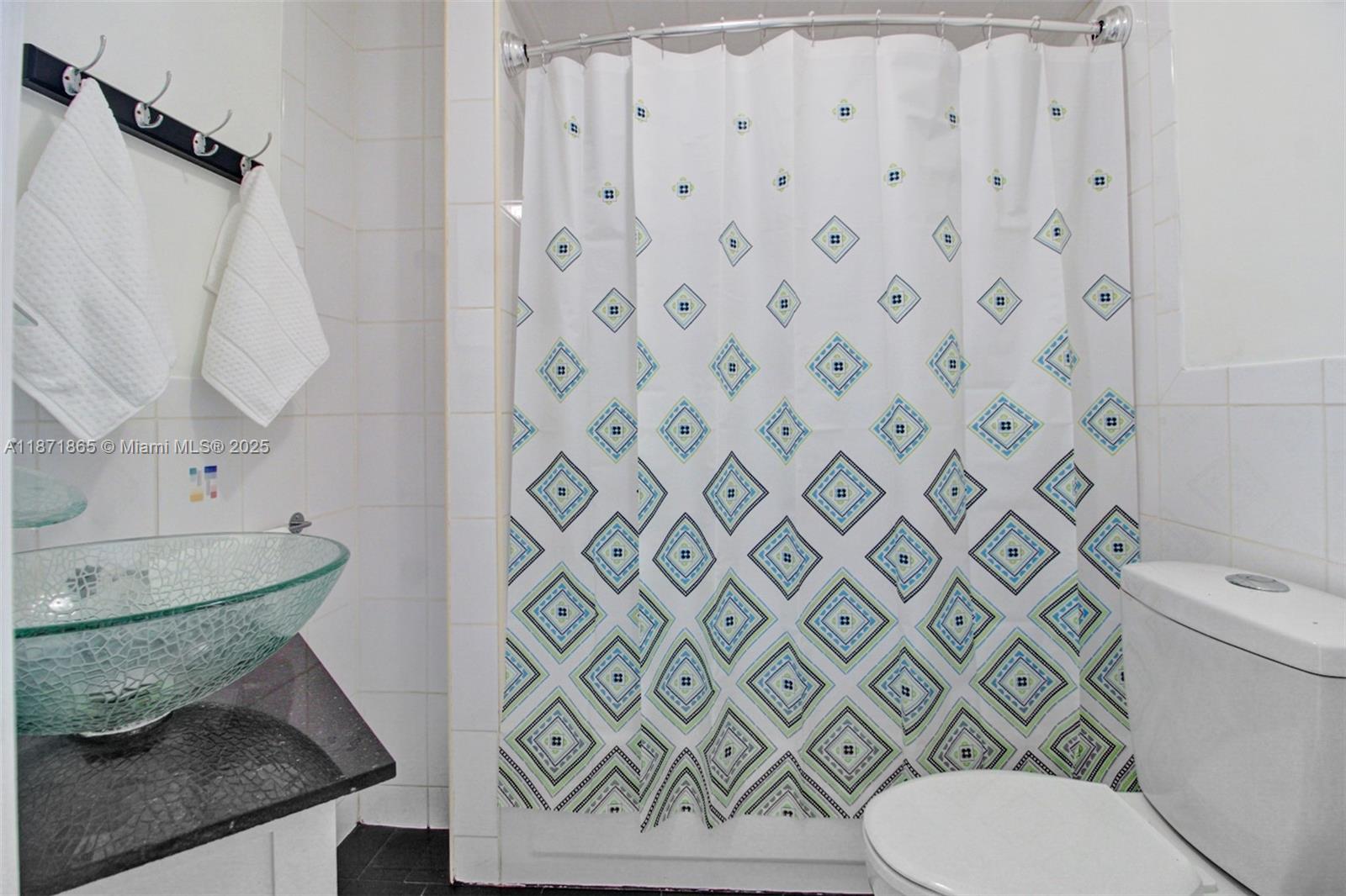 9930 Southwest 48th Street Miami, FL 33165 - Photo 18 of 29 a white toilet sitting next to a shower curtain