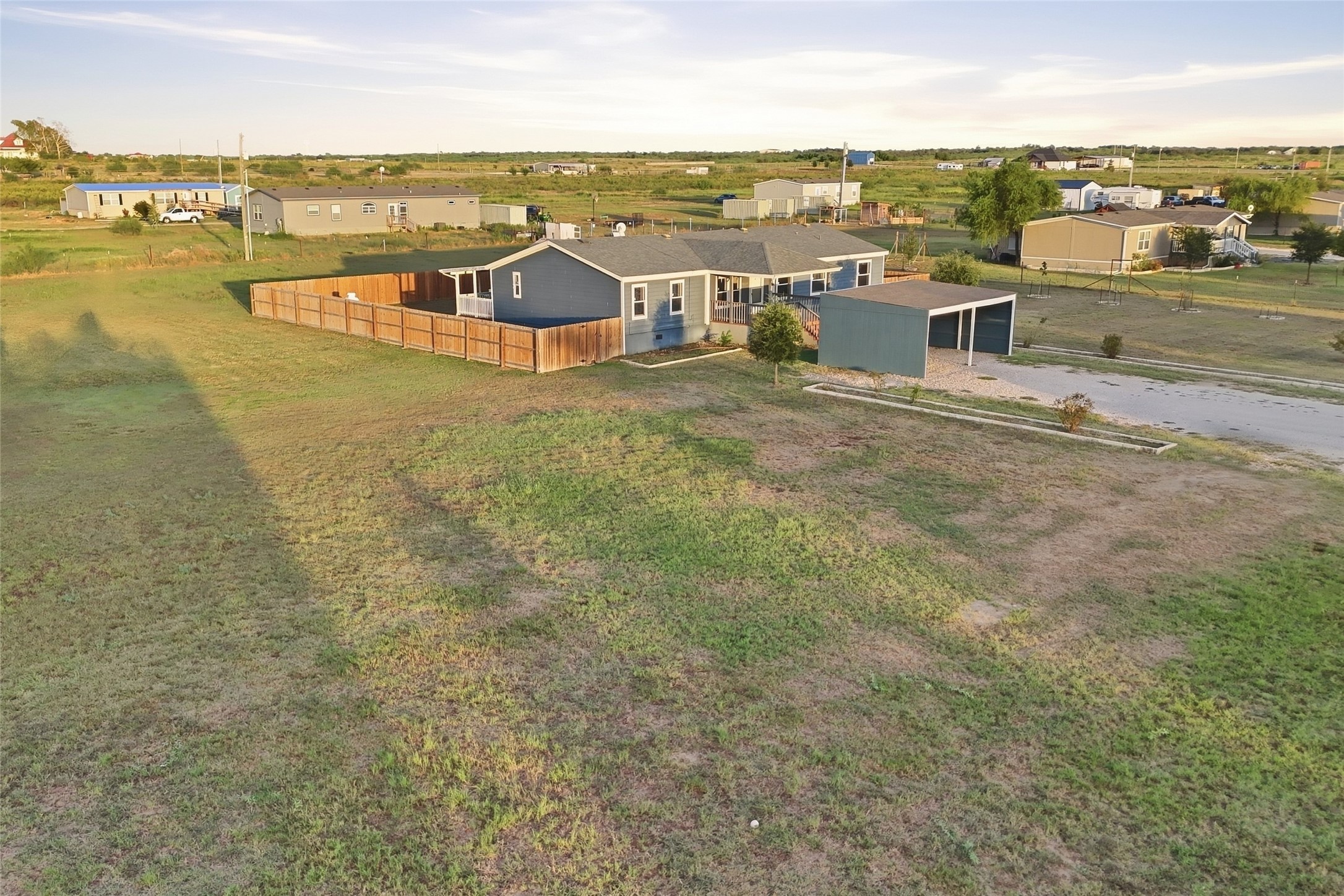 2709 County Road 463 Elgin, TX 78621 - Photo 24 of 32 An expansive grassy lot surrounds this one-story residence with a fenced backyard and carport.