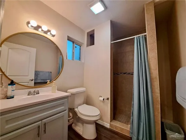 a bathroom with a toilet a sink and mirror