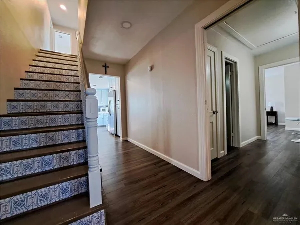 a view of a hallway with wooden floor and entryway