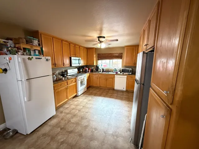 a kitchen with granite countertop stainless steel appliances a refrigerator a stove a sink and a window