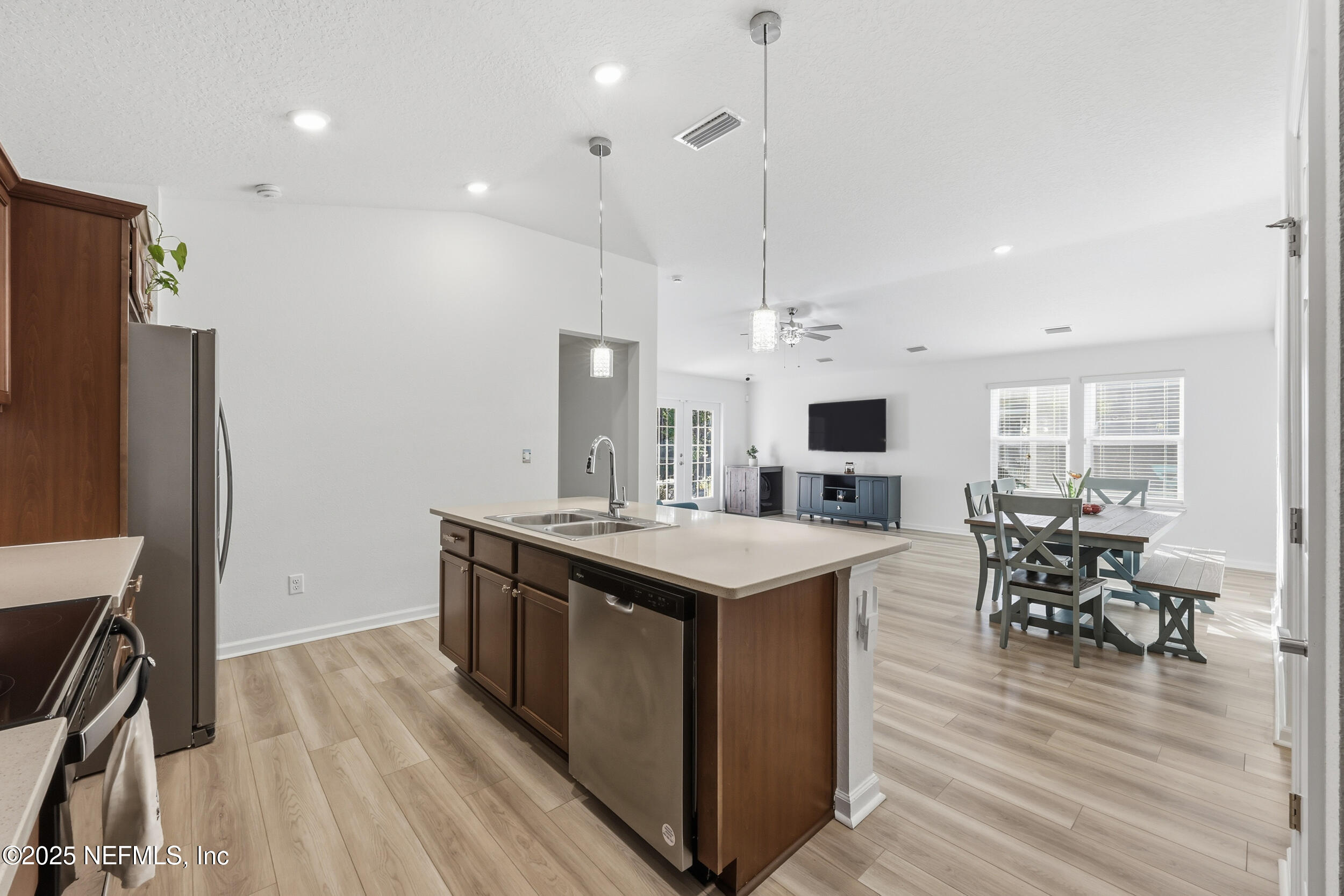 335 Boulder Lane St. Johns, FL 32259 - Photo 12 of 32 a kitchen with stainless steel appliances a stove top oven a refrigerator a dining table and chairs with wooden floor