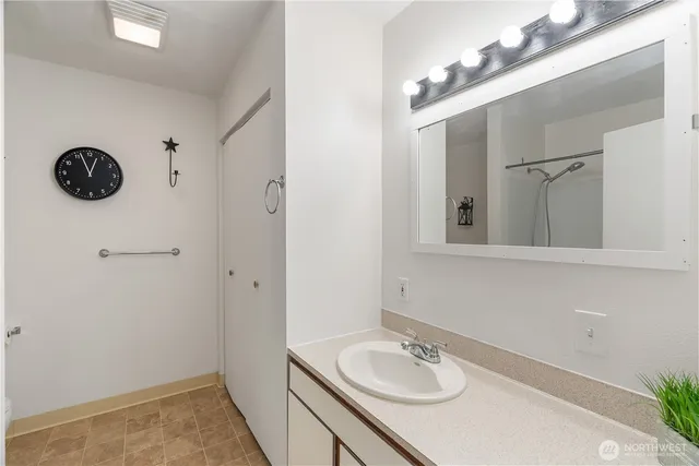 a bathroom with a sink vanity and a mirror