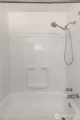 a bathroom with a bath tub with a shower