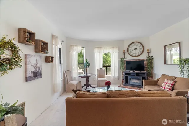 a living room with fireplace furniture and a large window