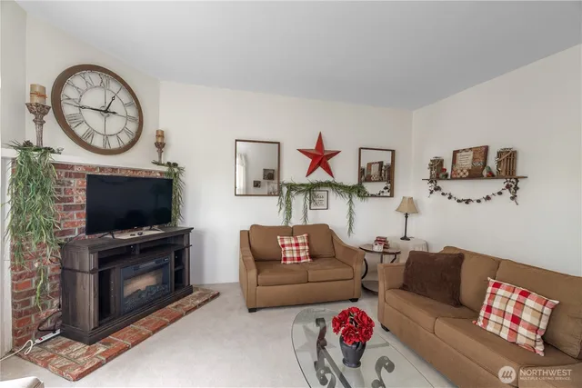 a living room with furniture a flat screen tv and a fireplace